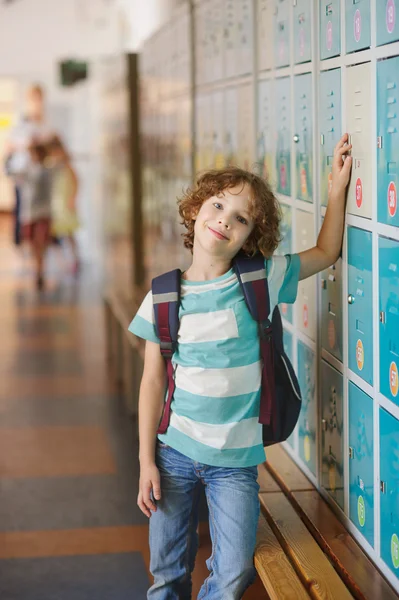Kleiner Schüler steht neben Schließfächern im Schulflur — Stockfoto