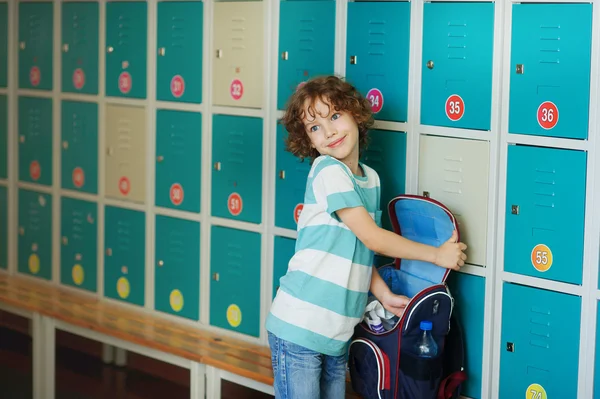 Petit écolier debout dans le couloir près des casiers . — Photo