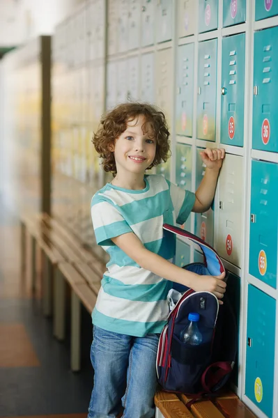 L'écolier debout près des casiers dans le couloir de l'école . — Photo