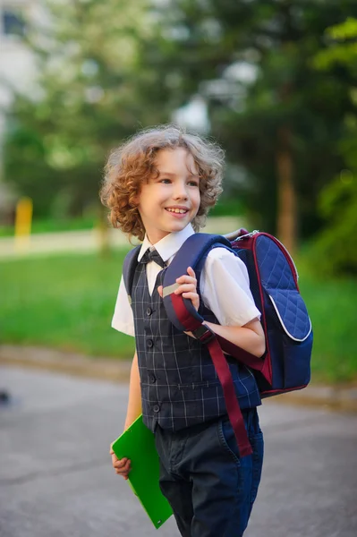 Kleiner Schüler steht auf dem Schulhof und lächelt. — Stockfoto