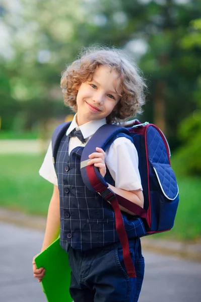 Söt liten första grader är på skolgården. — Stockfoto