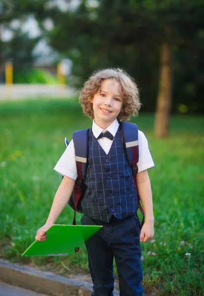 Pequeno estudante de pé no quintal da escola . — Fotografia de Stock