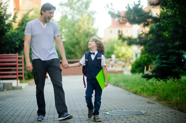 Bonito primeiro graduador está indo com seu pai para a escola . — Fotografia de Stock