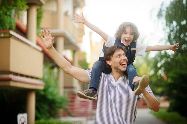 Primo alunno seduto sulle spalle di suo padre . — Foto Stock