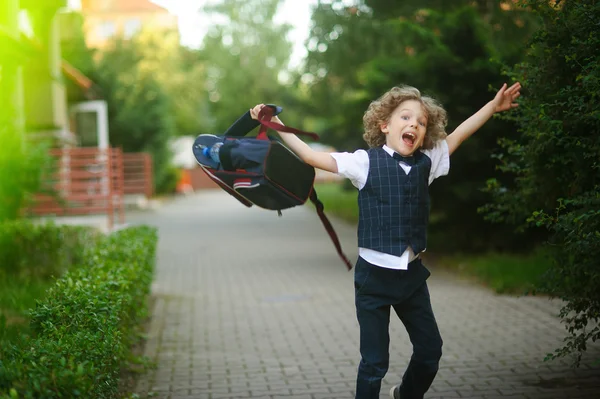 Der Schüler schwingt wütend seinen Rucksack auf dem Schulhof. — Stockfoto