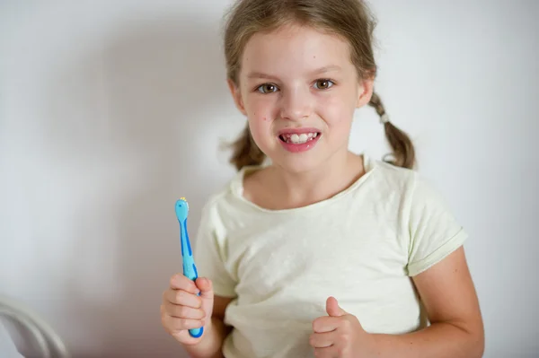 Linda niña con coletas diligentemente cepillándose los dientes . —  Fotos de Stock