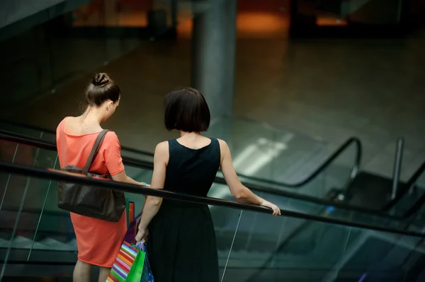 Dwie młode kobiety na schodniku w centrum handlowym. — Zdjęcie stockowe