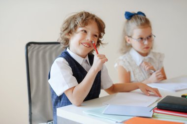 Komik küçük öğrenciler bir masada oturmak.