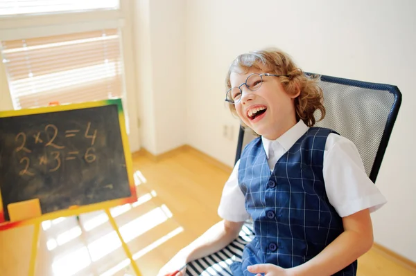 Funny little schoolboy in glasses cheerfully laughs. — Stock Photo, Image
