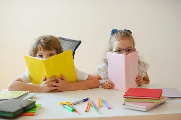 Zwei junge Klassenkameraden, Junge und Mädchen, sitzen am gleichen Schreibtisch. — Stockfoto
