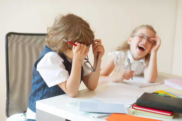 Schüler einer Grundschule, Junge und Mädchen, sitzen am gleichen Schreibtisch. — Stockfoto