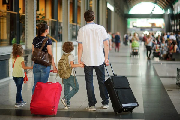 Giovani genitori con due bambini in stazione . — Foto Stock