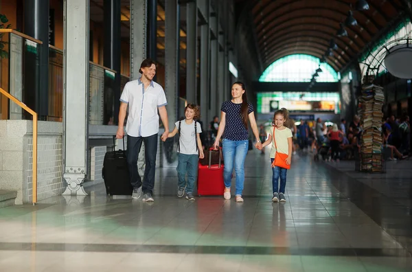 Padre, madre e due bambini passano davanti alla sala d'attesa della stazione. . — Foto Stock