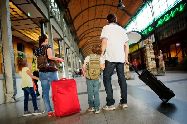 Padre, madre e due bambini stanno in una sala d'attesa alla stazione . — Foto Stock