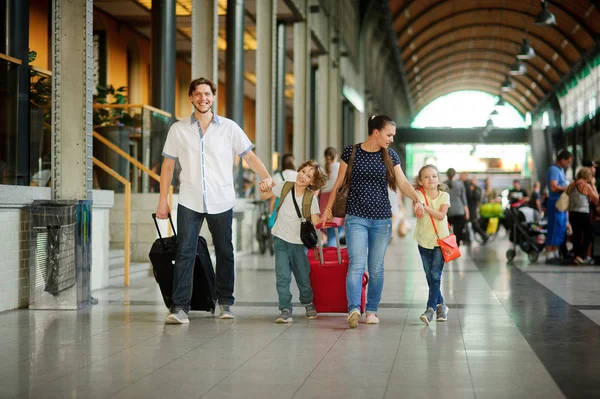Young family with two children at train station.