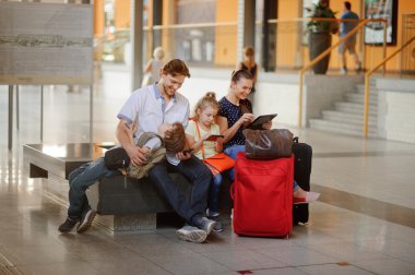 Young parents with two children at the railway station.