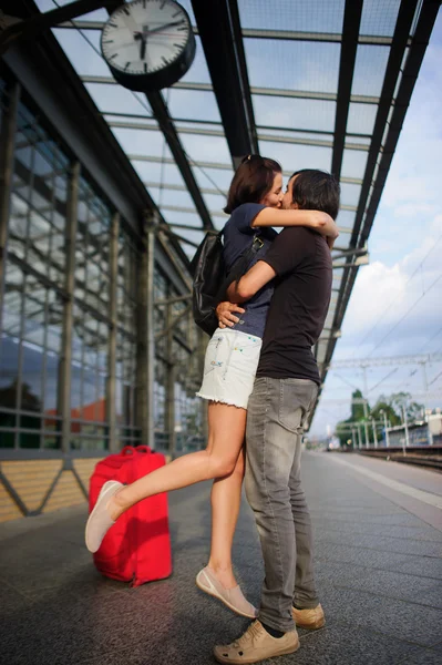 Liefdevolle paar Snog op het platform onder de klok. — Stockfoto