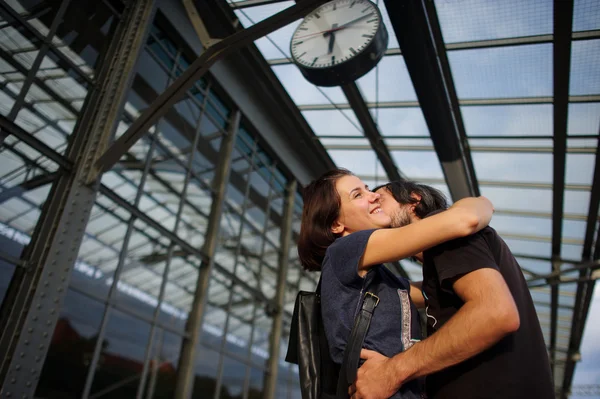 Loving couple met or parted on the platform under the clock. — Stock Photo, Image