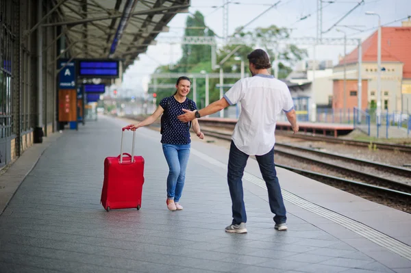 На пустой платформе бежит молодая женщина с красным чемоданом . — стоковое фото