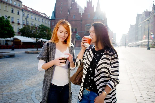 Twee jonge vrouwen zijn blij om koffie te drinken in het centrum van de prachtige Europese stad. — Stockfoto