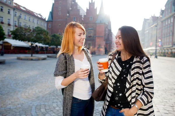 Två söta flickor-turister pratar när du står på torget i den vackra europeiska staden. — Stockfoto