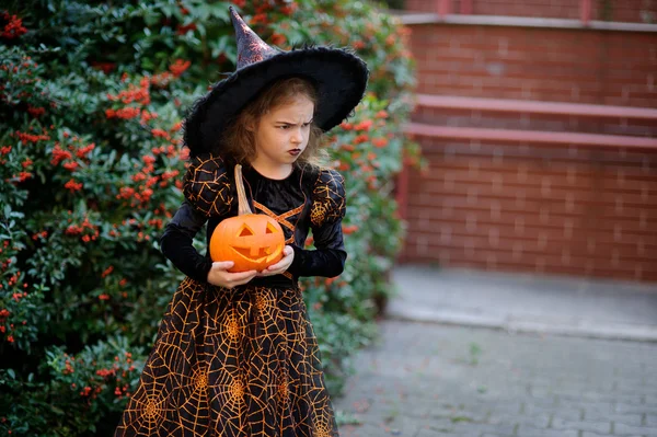 Allerheiligen. Nettes kleines Mädchen porträtiert die böse Hexe. — Stockfoto