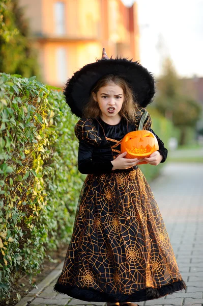 Am Vorabend von Allerheiligen. Kleines Mädchen porträtiert die böse Zauberin. — Stockfoto