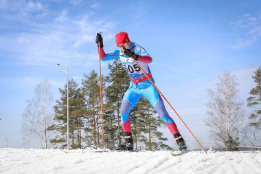 Kayakçı kış havasında kayak pistinde gezer. Kayakçı kayarak yükselişin üstesinden gelir
