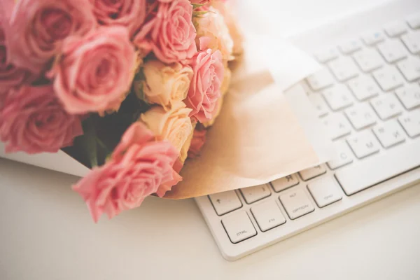 Roses on white computer keyboard — Stock Photo, Image