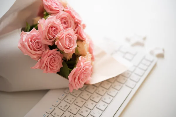 Roses on white computer keyboard — Stock Photo, Image