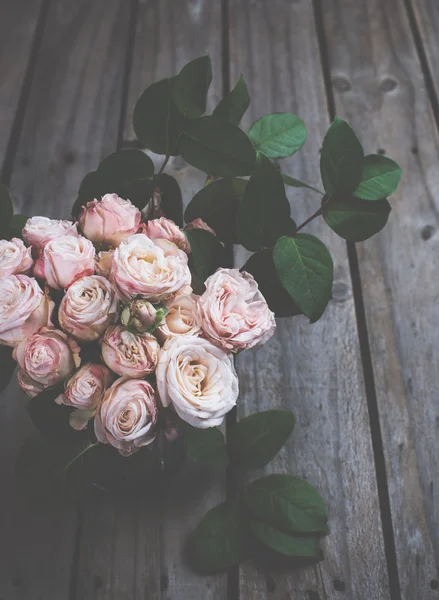 Hermoso ramo vintage de rosas frescas en tablero de madera —  Fotos de Stock