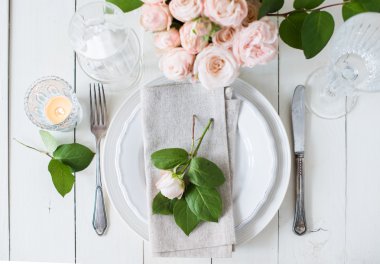 Düğün masa süslemeleri gül, mumlar, çatal bıçak takımı ile bir