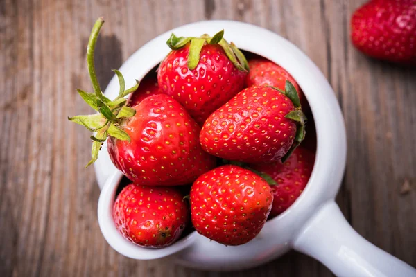 Red organic strawberries in white bowl — Stock Photo, Image