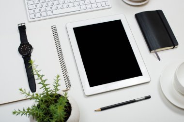 Beyaz masa üstü arka plan üzerinde tablet mock-up ve ofis malzemeleri