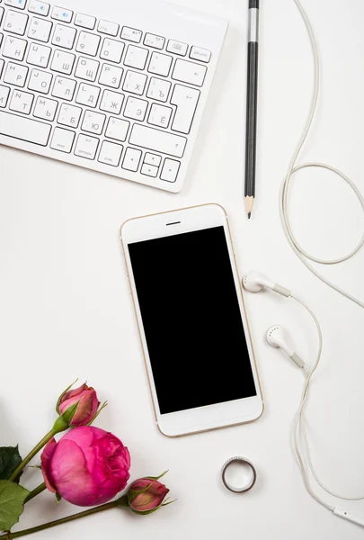 Smartphone, computer keyboard and fesh pink flowers on white tab — Stock Photo, Image