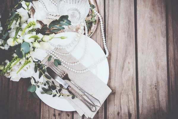 Винтажный декор свадебного стола, посуда, цветы и жемчужные бусы — стоковое фото