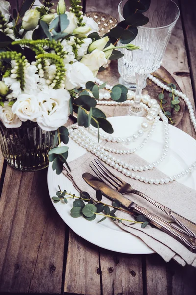 Винтажный декор свадебного стола, посуда, цветы и жемчужные бусы — стоковое фото