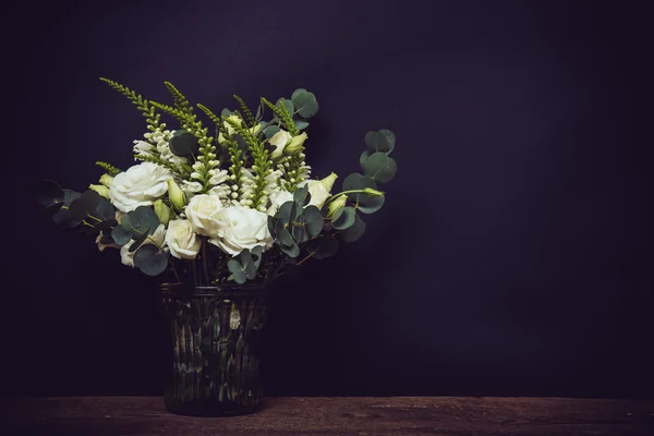 White flowers on an old wooden board with black chalkboard — Stock Photo, Image
