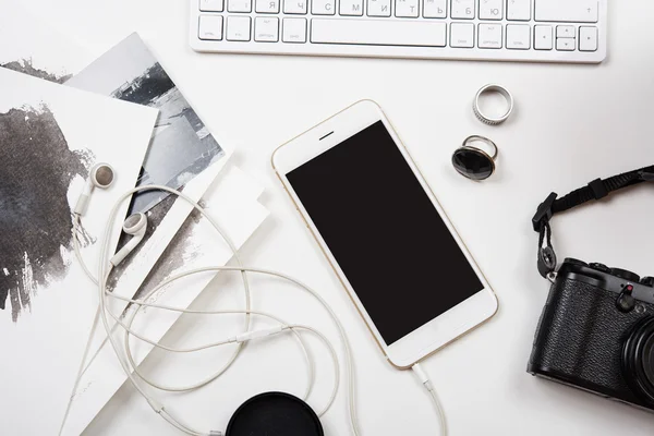 Modern smartphone, computer keyboard and photo camera on white t — Stock Photo, Image