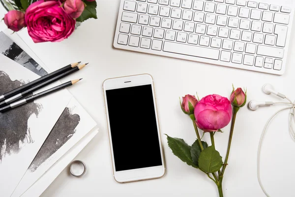 Smartphone, computer keyboard and fesh pink flowers on white tab — Stock Photo, Image