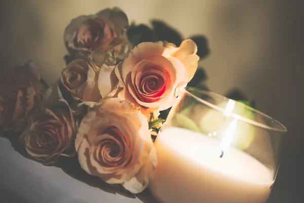 Belle rose beige e candela accesa — Foto Stock