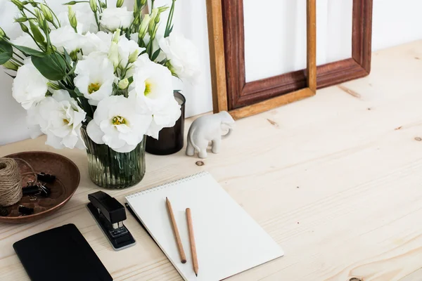 Vitt skrivbord med samtida feminin med blommor — Stockfoto