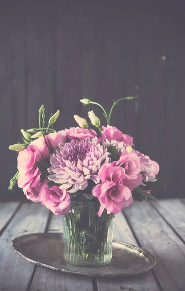 Bouquet of pink flowers in vase vintage decor — Stock Photo, Image