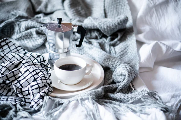 Cup of coffee on tray in cozy winter bad with wool blanket — Stock Photo, Image