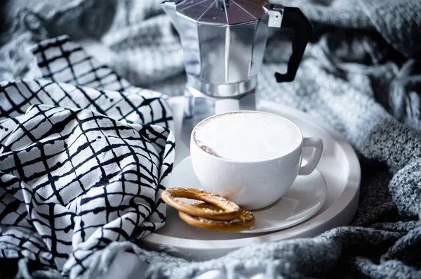 Cup of coffee on tray in cozy winter bad with wool blanket — Stock Photo, Image