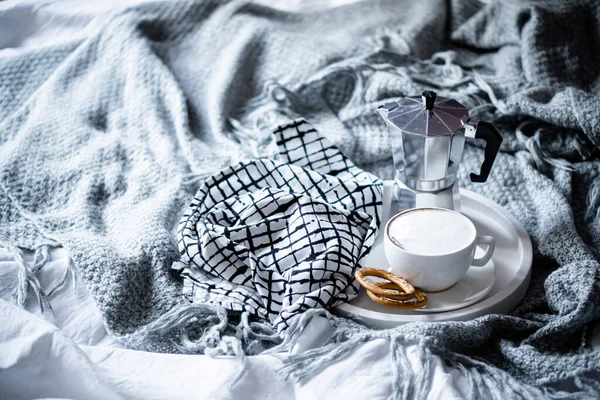 Cup of coffee on tray in cozy winter bad with wool blanket — Stock Photo, Image