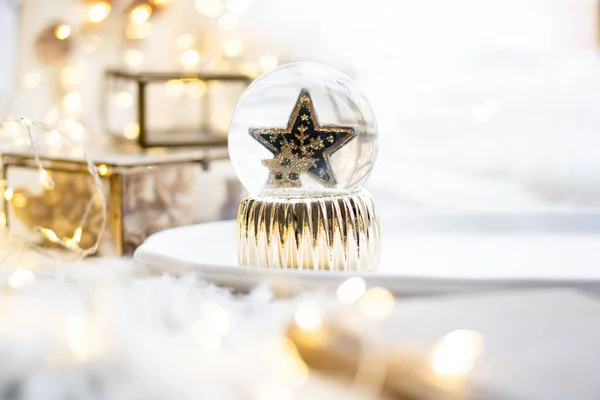 Zlatá vánoční hvězda ve skleněné kouli, novoroční dekorace — Stock fotografie