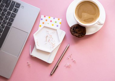 Bayan blogcular iş yerinde, bir fincan kahve ve pembe masa üstünde dizüstü bilgisayar klavyesi