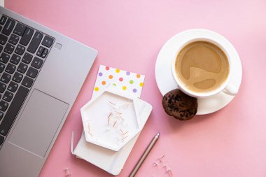 Bayan blogcular iş yerinde, bir fincan kahve ve pembe masa üstünde dizüstü bilgisayar klavyesi