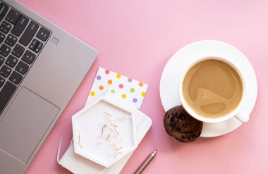 Bayan blogcular iş yerinde, bir fincan kahve ve pembe masa üstünde dizüstü bilgisayar klavyesi